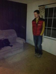 Living room with wood paneling, old couch and carpet